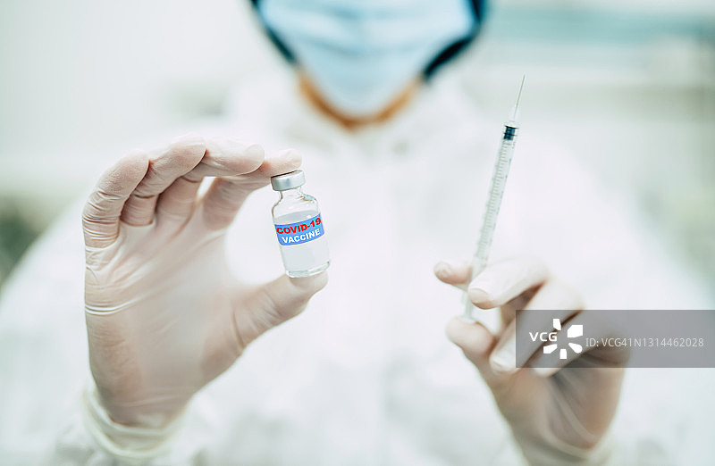 医生、护士或科学家戴着蓝色手套，手持covid-19疫苗疾病，准备进行人体临床试验，接种疫苗、药物和药物概念。图片素材