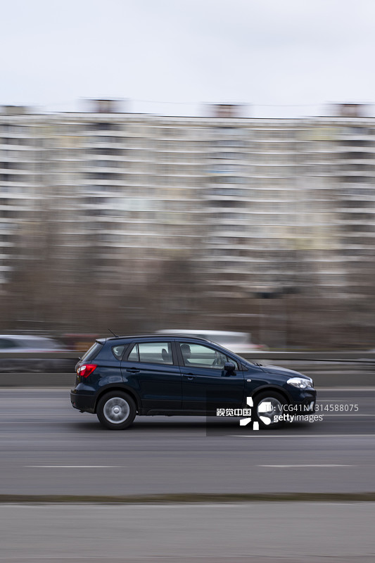 蓝色的铃木SX4car在街上移动。图片素材