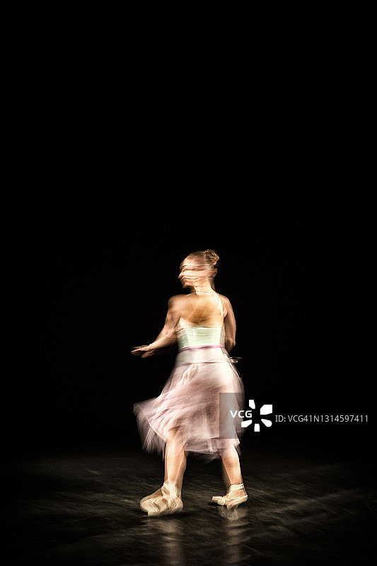 芭蕾舞女演员在黑色背景下跳舞图片素材