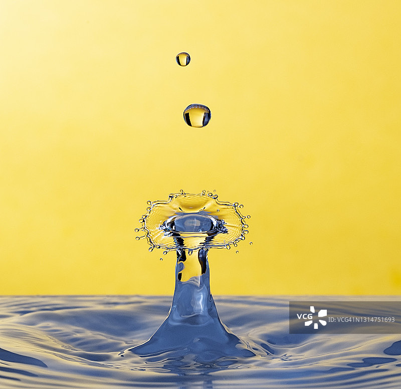 水滴的碰撞(水蘑菇)，在一个黄色的背景图片素材