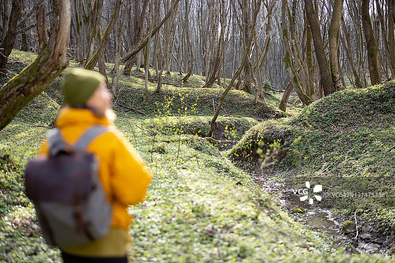 女人在绿色的春天的森林里徒步旅行的衣服图片素材