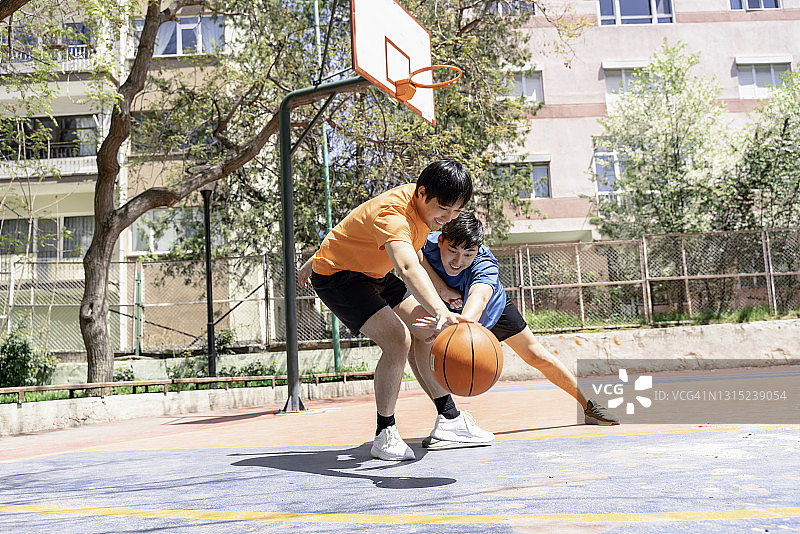年轻的亚洲男性在户外打篮球图片素材