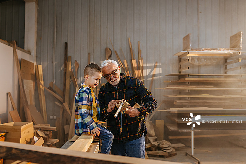 男孩和爷爷在木匠作坊图片素材