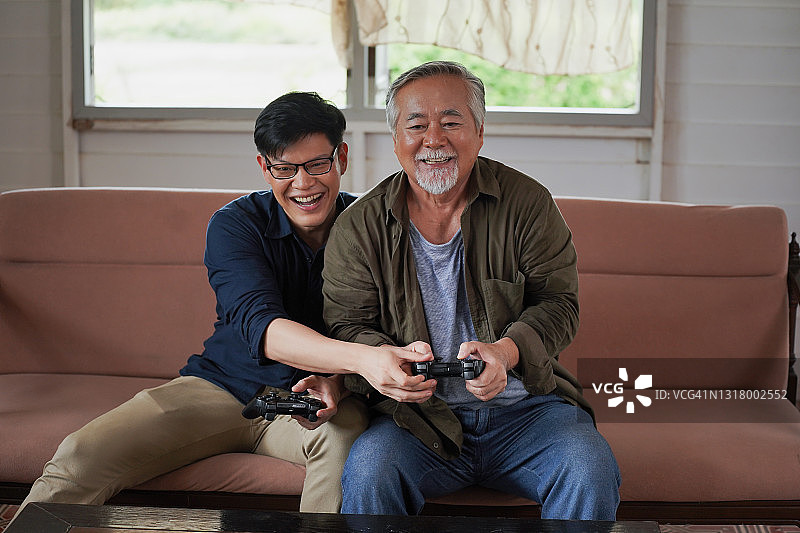 父亲和儿子玩游戏，有乐趣的关系在家庭图片素材