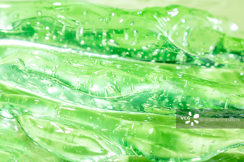 透明的绿色液体保湿血清涂抹脸部。透明质酸保湿。抗菌芦荟凝胶泡沫。用于皮肤护理的化妆品。美容。图片素材