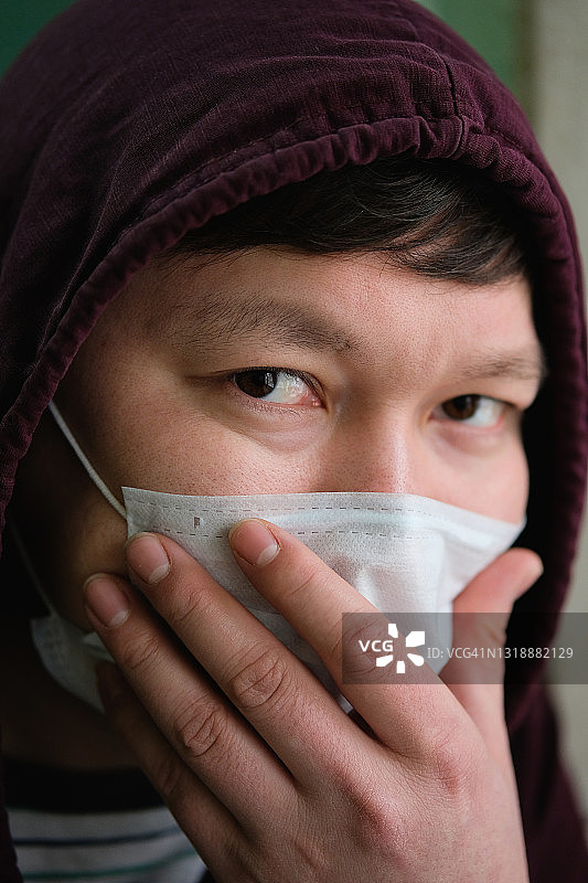 亚洲或的流感患者戴上医用防护口罩，看着镜头。空气污染的概念，肺炎和冠状病毒的爆发，流行病和病毒感染的风险。图片素材