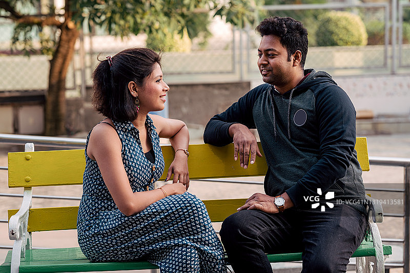 浪漫的印度夫妇坐在长凳上互相交谈图片素材