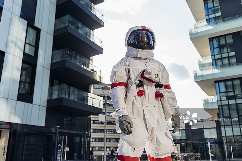 戴着太空头盔的男宇航员站在建筑物中图片素材