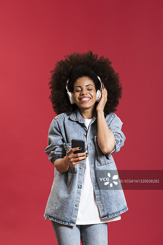 快活的黑人妇女戴着耳机听音乐图片素材