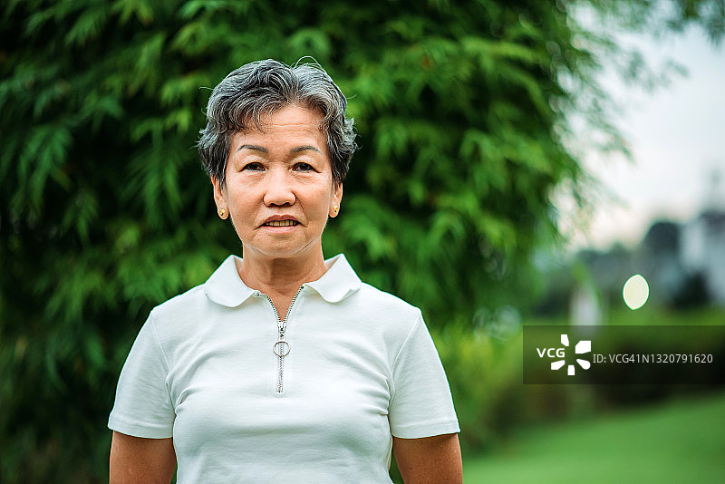 肖像亚洲华人微笑活跃的老年妇女在公园锻炼图片素材