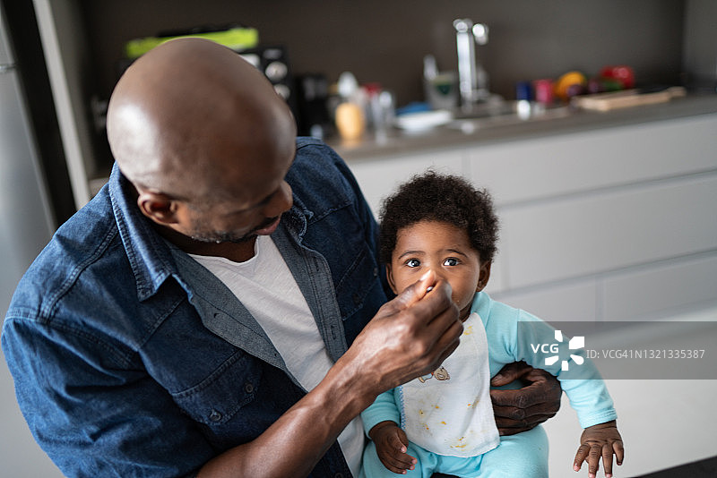 父亲在家里给男婴喂奶图片素材