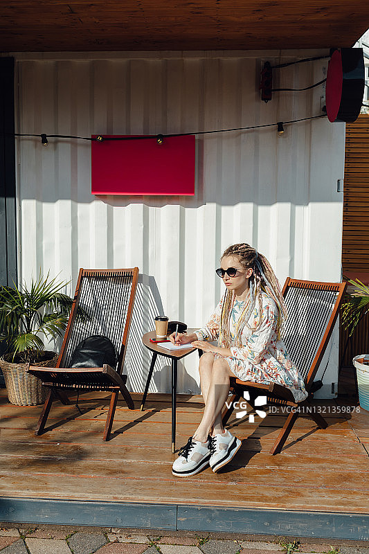 一个年轻的欧洲女人坐在街上的咖啡馆里图片素材