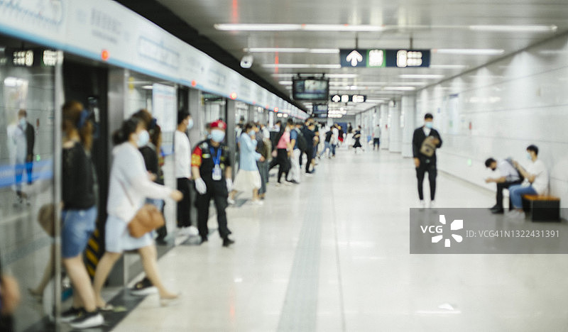一群带着防护口罩的忙碌通勤者在北京地铁里行走图片素材