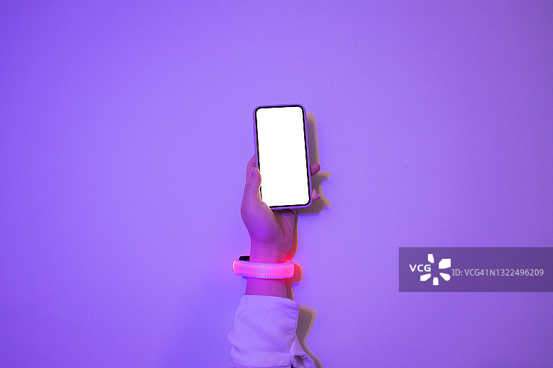 女人用手机时戴着发光的智能手表图片素材