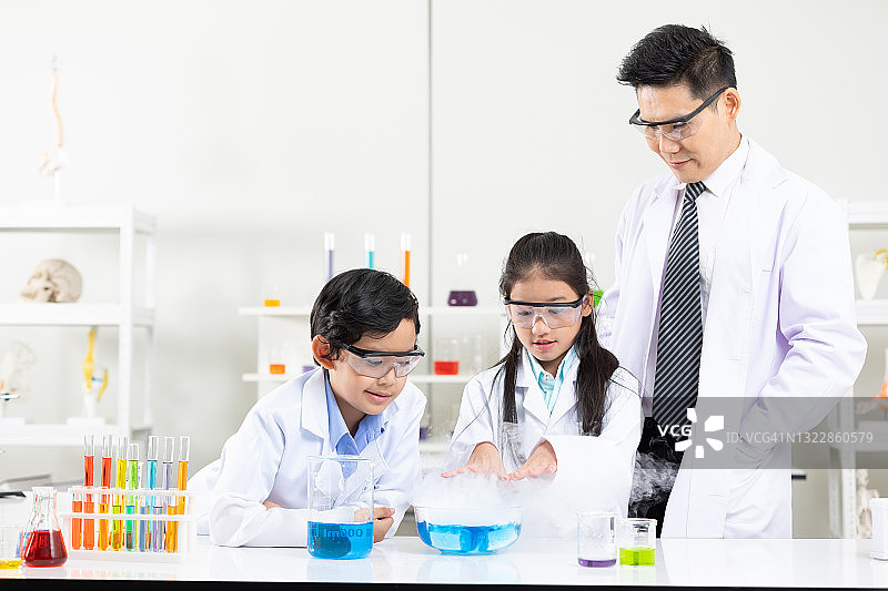 在实验教室里，孩子们在科学老师的陪同下做化学实验图片素材