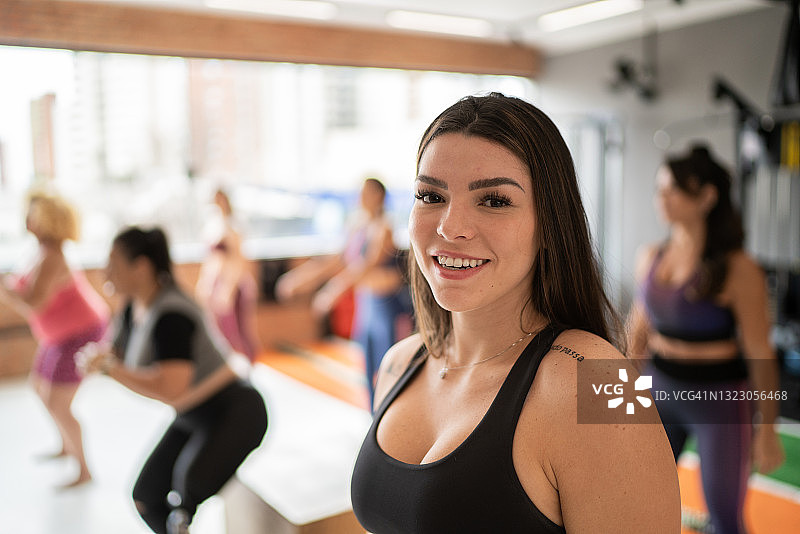 一个快乐的年轻女子在健身房的肖像图片素材