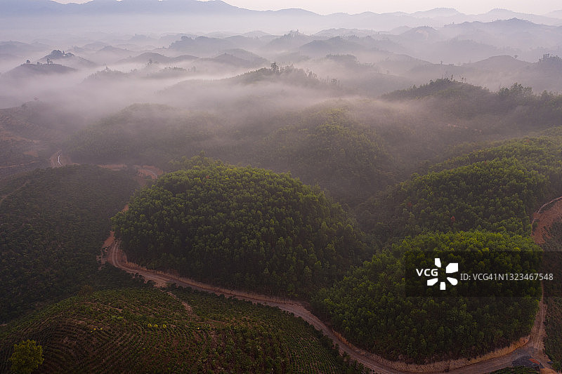 越南风景-起伏的山丘和山脉在一个阳光明媚的日子与雾从B'Lao鸟瞰图图片素材