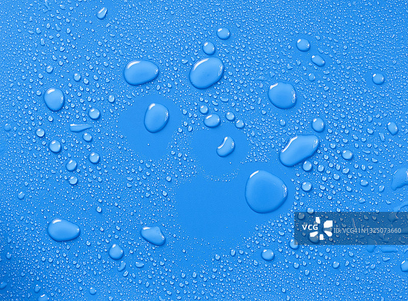 蓝色背景上的水滴和水花的完整框架。图片素材