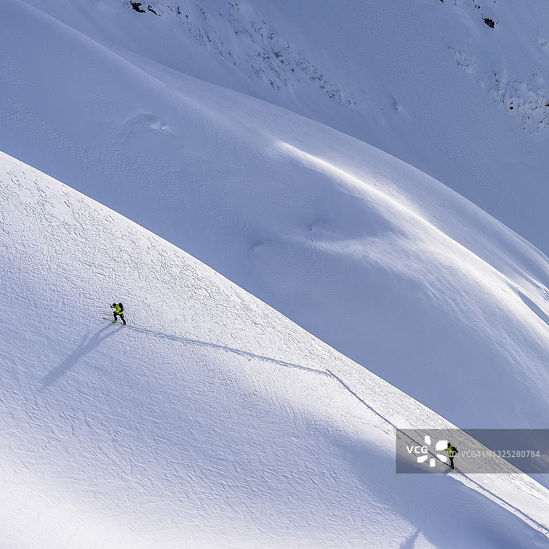 偏远地区的滑雪者攀登冰雪覆盖的加拿大落基山脉图片素材