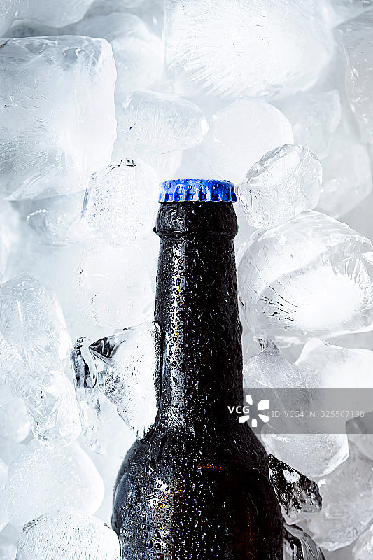 一瓶冰镇啤酒加冰块。精酿啤酒。图片素材