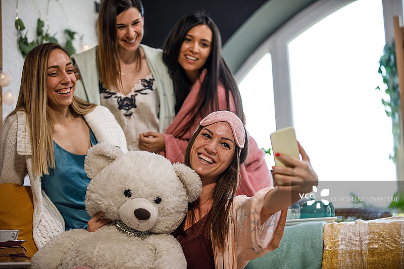 闺蜜们和一个巨大的泰迪熊玩具自拍图片素材