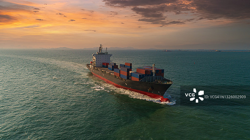 鸟瞰图集装箱货船全速以美丽的波浪模式在海上运输业务物流，进出口，海运或货运。图片素材