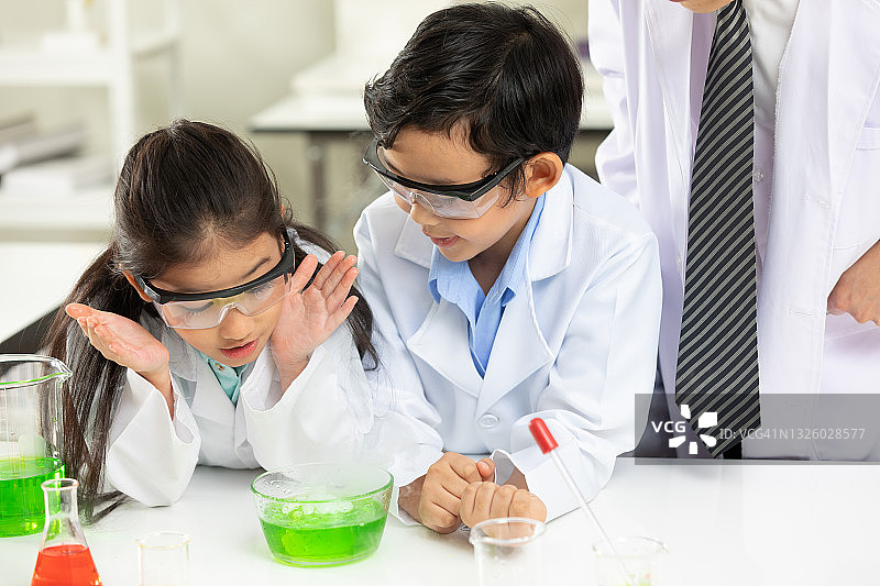 在实验教室里，学生和科学老师一起做化学实验图片素材