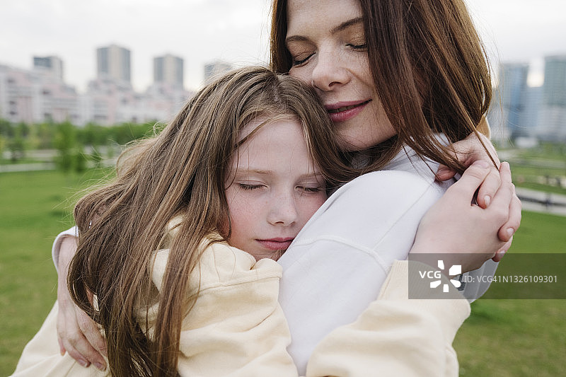 女儿在公园拥抱母亲图片素材