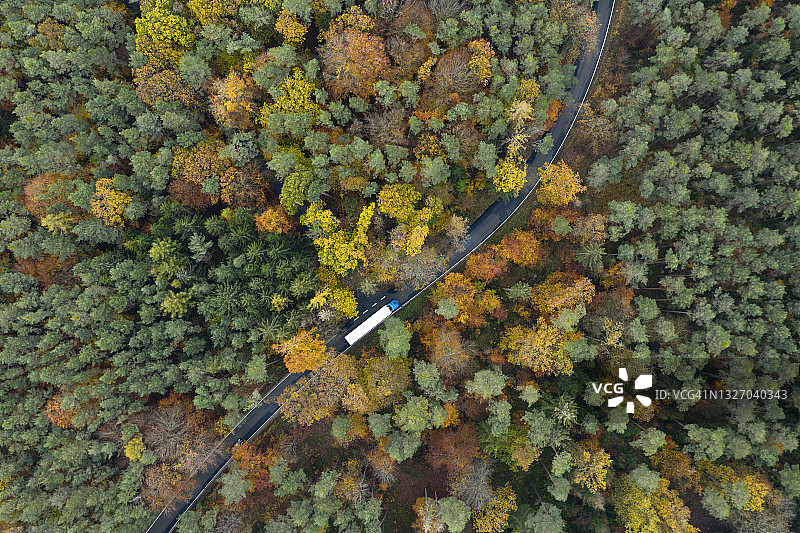 秋天卡车通过森林的道路鸟瞰图。施泰格瓦尔德，弗朗哥尼亚，德国，欧洲。图片素材