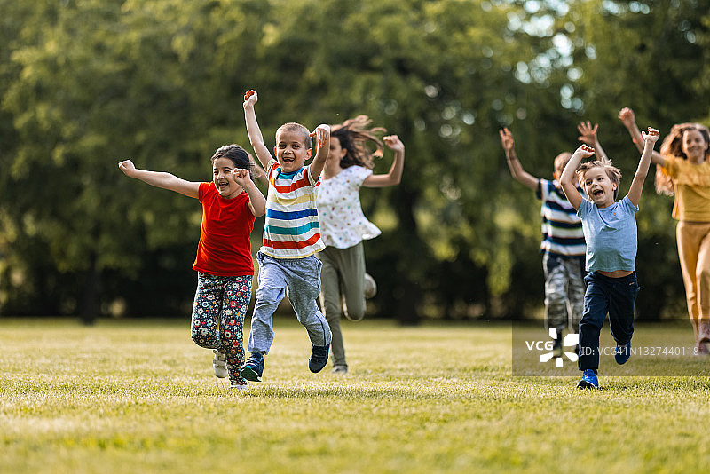 快乐的孩子们在草地上奔跑玩耍图片素材