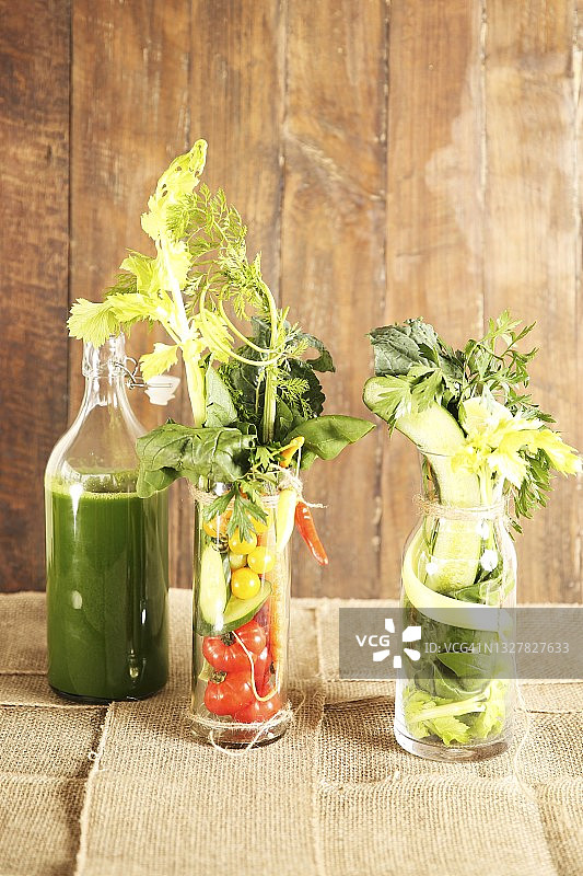 健康的混合蔬菜汁与成分在玻璃杯和一个瓶子图片素材