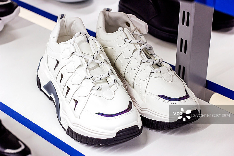 新的白色运动鞋在零售服装商店的展示架上图片素材