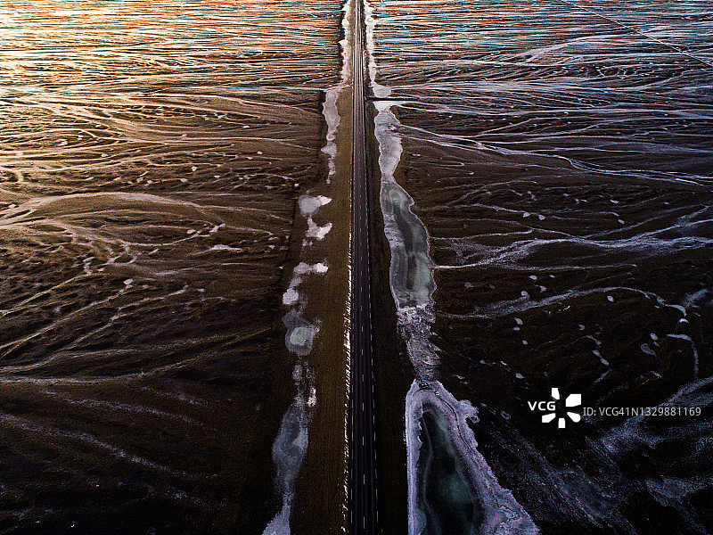 无人机拍摄的冰岛1号公路在日落时穿越熔岩平原的路段图片素材