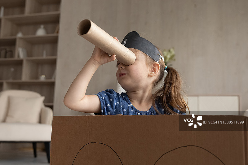可爱可爱的小女孩戴着海盗帽看着望远镜图片素材
