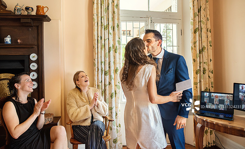 新婚夫妇在家中直播他们的婚礼时接吻图片素材