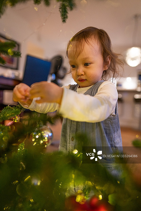 圣诞树旁有个可爱的小女孩图片素材
