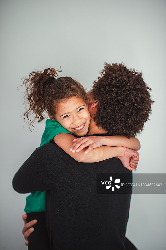 女孩拥抱着爸爸，看着镜头微笑着图片素材