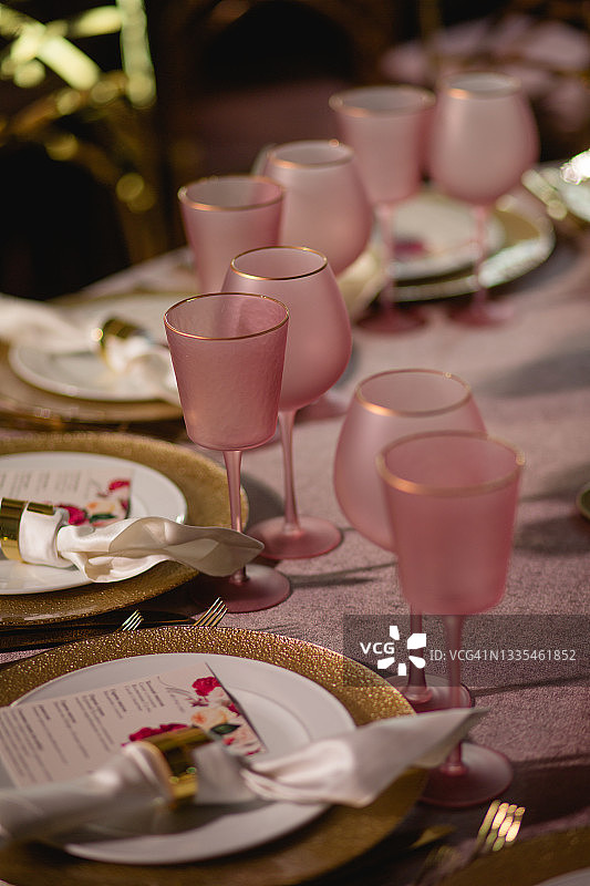 时髦的哑光粉色眼镜和桌上的金色盘子图片素材