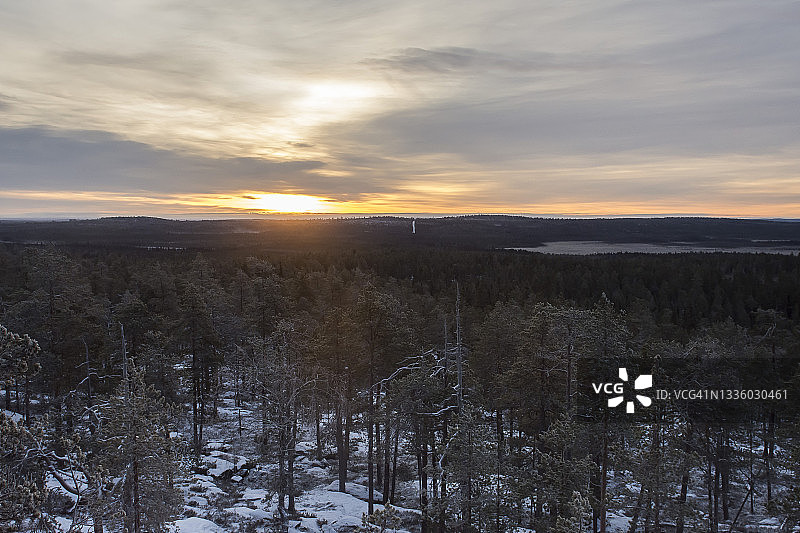 日落在冰雪覆盖的北极森林景观，罗瓦涅米，芬兰拉普兰图片素材