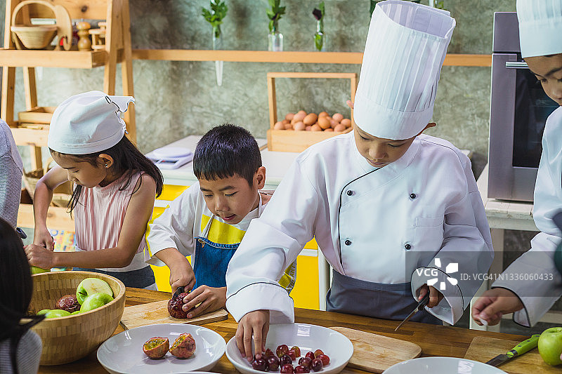 一群亚洲孩子在学校厨房里准备水果做冰沙图片素材