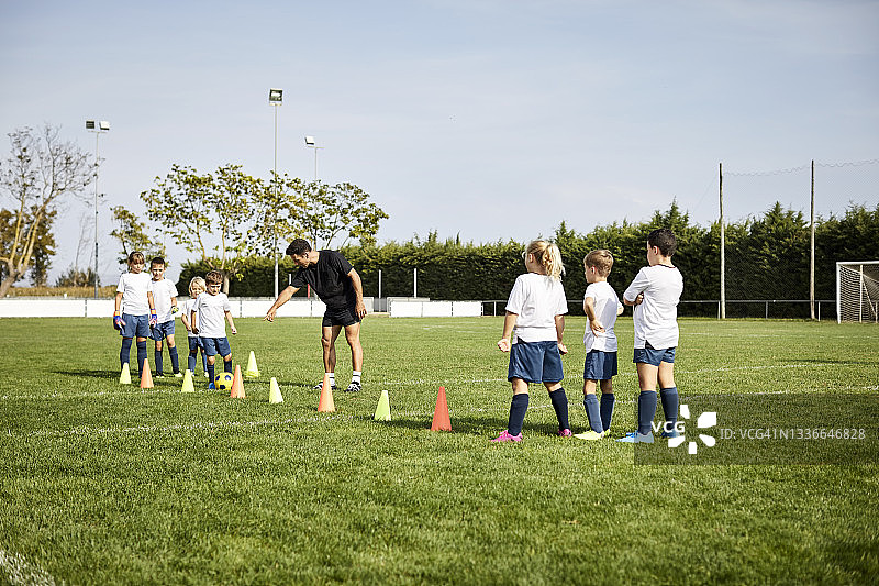 足球教练在球场上训练孩子图片素材