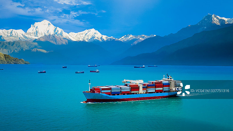 集装箱船运输国际范围内包括亚太和欧洲的大型货物物流进出口货物，工业商业服务集装箱船运输在海或地中海山脉岩石背景图片素材