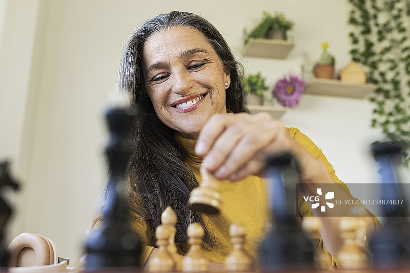 微笑的女人在家里下棋图片素材