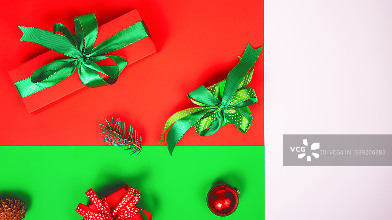 新年作文与红色和绿色的礼品盒和圣诞节装饰的颜色背景。平的。本空间图片素材
