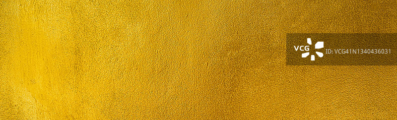 金色旧垃圾墙混凝土纹理作为背景，宽横幅。图片素材