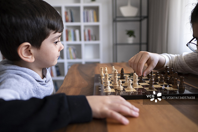 弟弟在家里一起下棋。家人在家里。图片素材