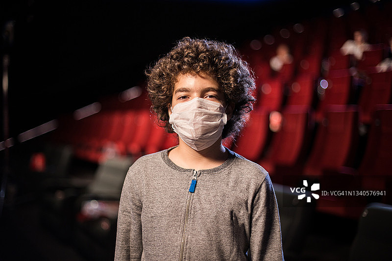 电影院里一个戴着防护面具的男孩的肖像图片素材