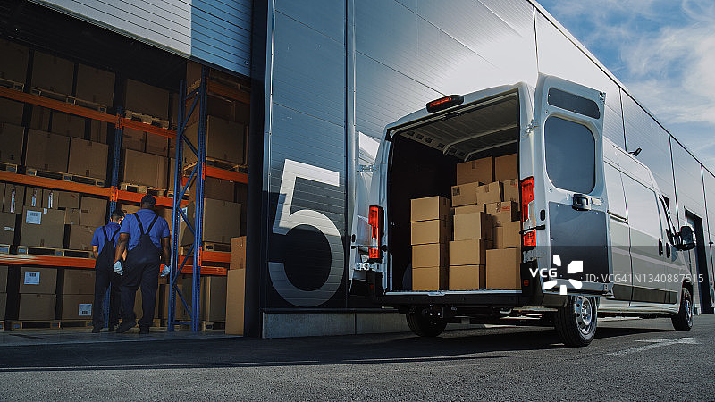 物流配送仓库外:两名工人装载纸箱运送卡车，开车送网上订单，采购，电子商务货物。图片素材
