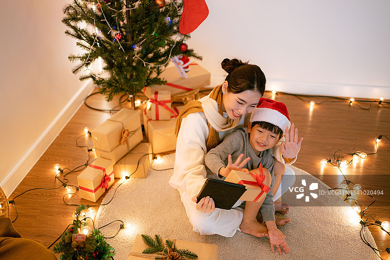 圣诞期间，母亲和儿子与家人进行视频通话。图片素材