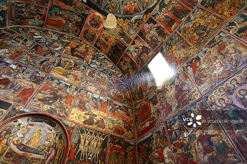 古老的基督教修道院内部，墙壁上覆盖着宗教壁画，光线从窗户透进来图片素材